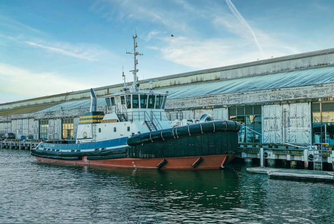 a tug boat docked in a harbor next to a building